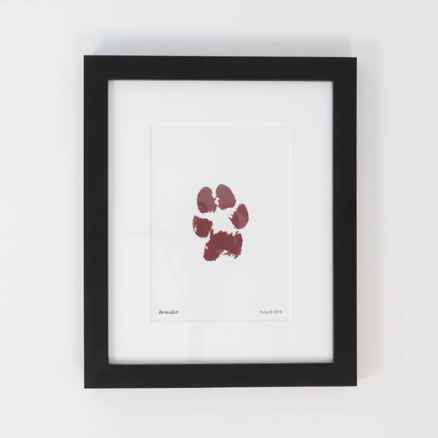 Paw print keepsake. Framed memorial print in plum with a black frame.